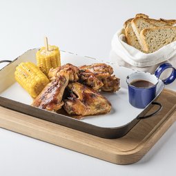 Roasted chicken wings with barbecue sauce, grilled corn-on-the-cob and bread from our oven