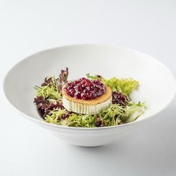 Assortment of shredded lettuce leaves with pomegranate, grilled goat cheese and cranberries